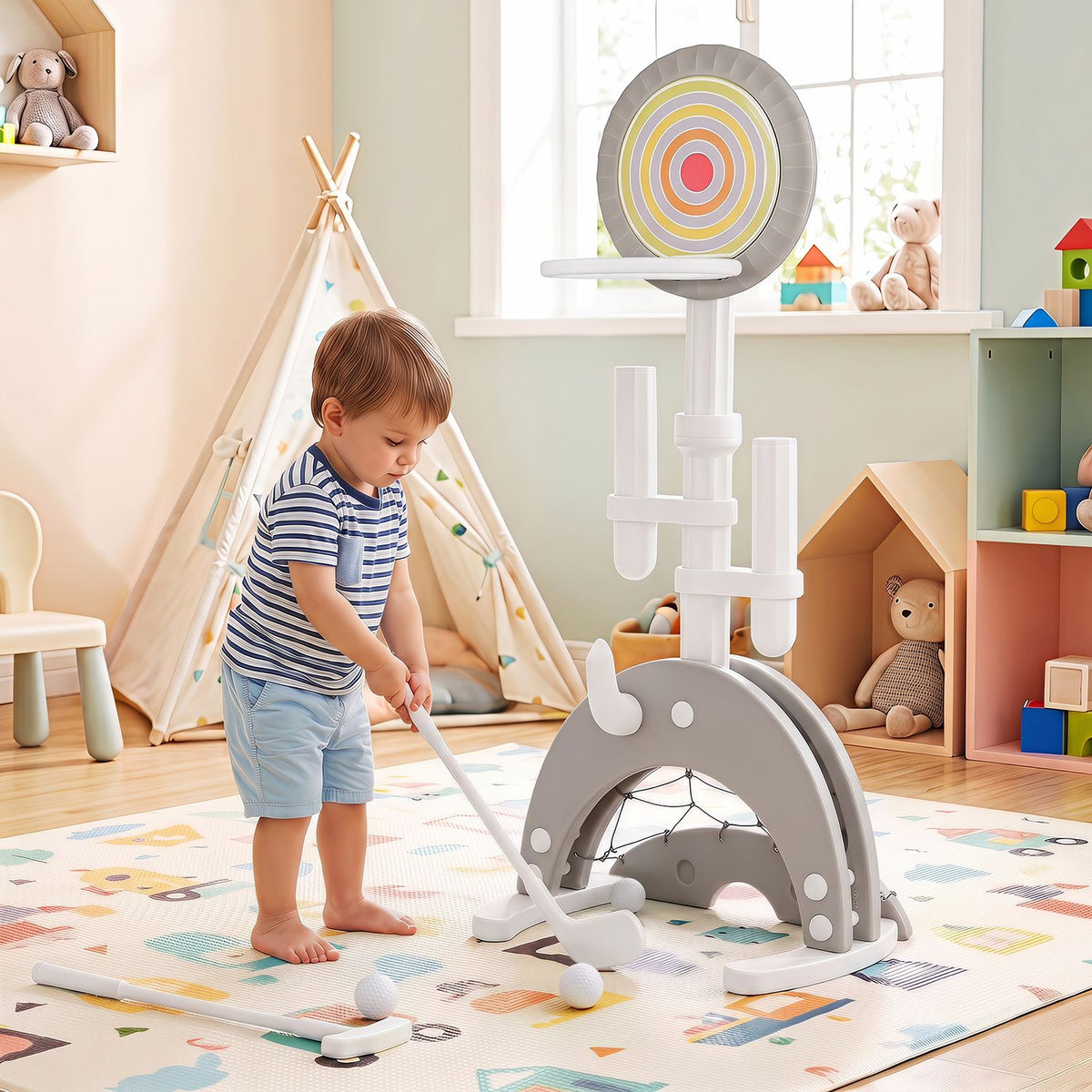 A toddler uses a small club beside the hoop on a colorful playroom rug.