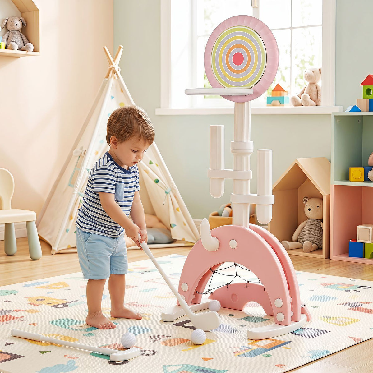 A toddler uses a club beside the pink hoop in a bright playroom.