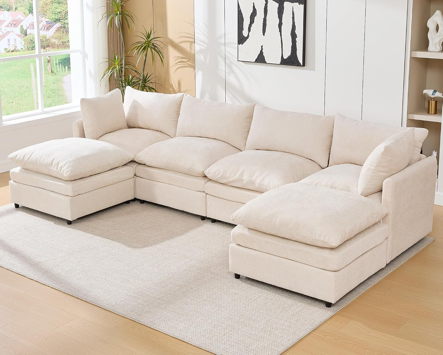 Cream four-seat U-shaped sectional with two ottomans in a living room.