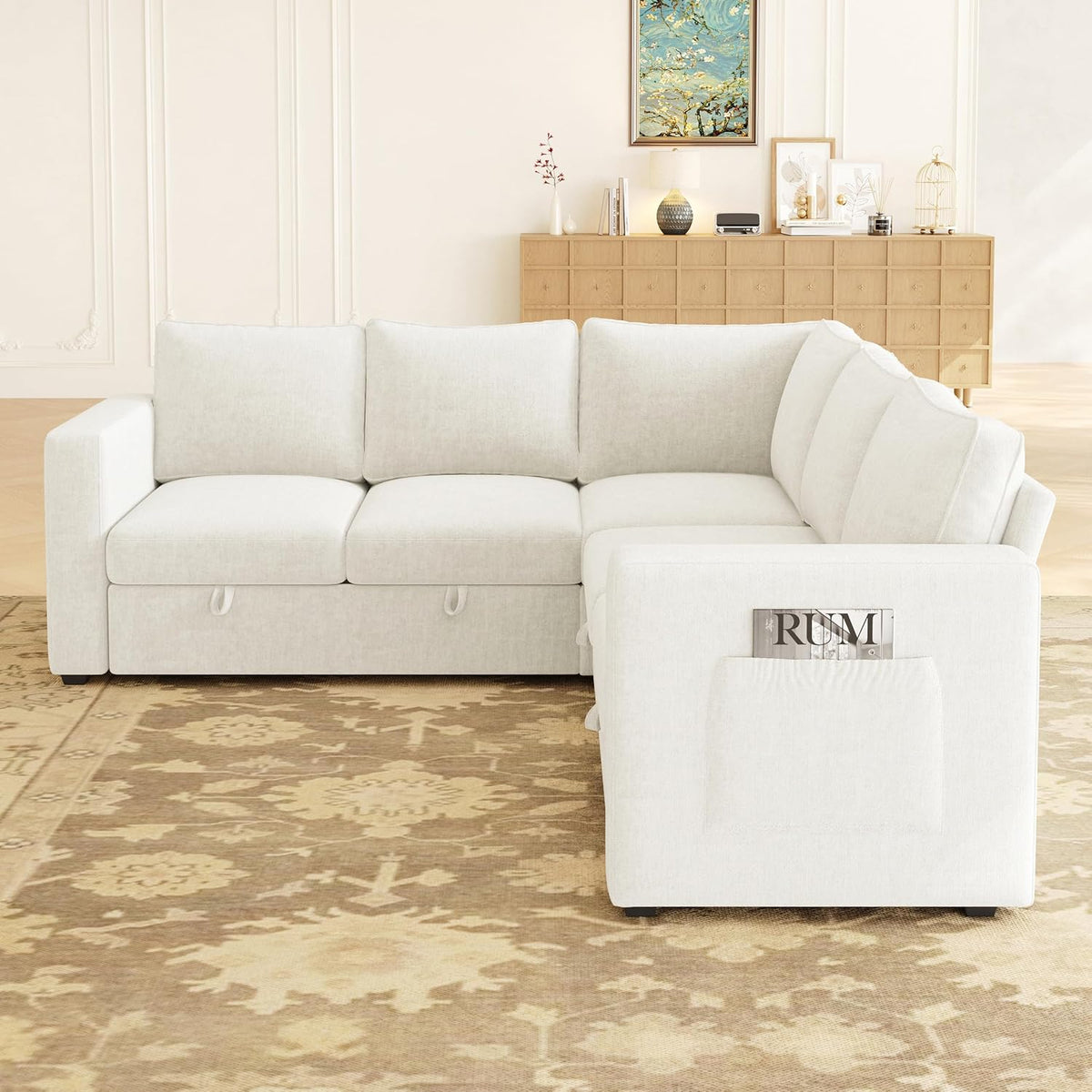 Front-facing view of the sectional in a staged room, showing an arm pocket holding a magazine on the chaise end.