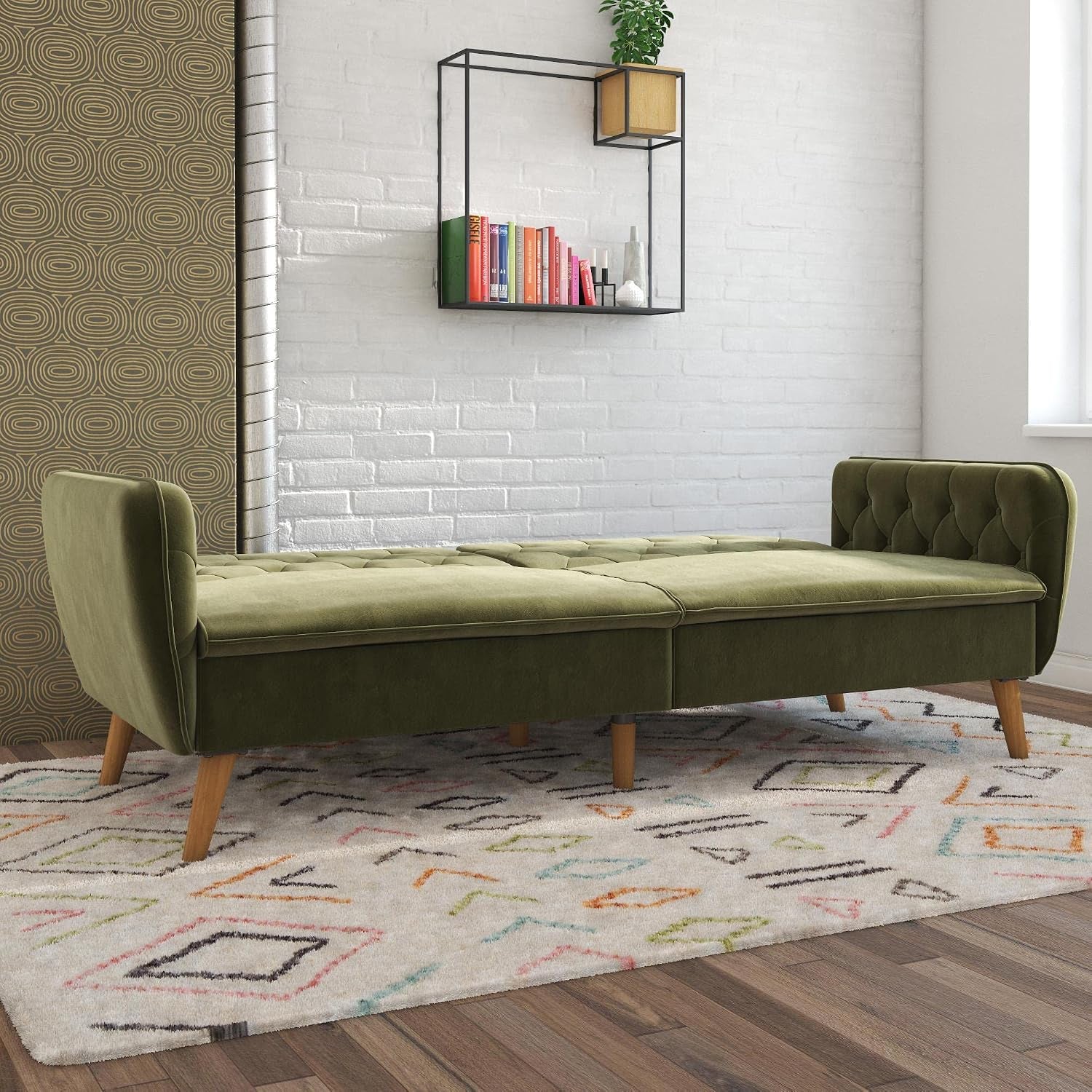 Green velvet futon shown flat in sleeping configuration with tufted backrests and wooden legs