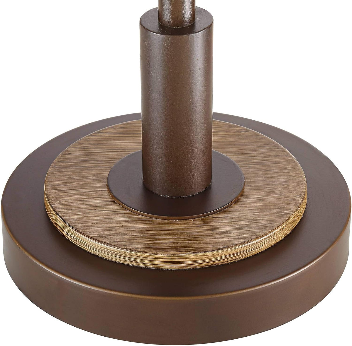 Round bronze base with wood-grain metal accent and cylindrical post, close-up detail