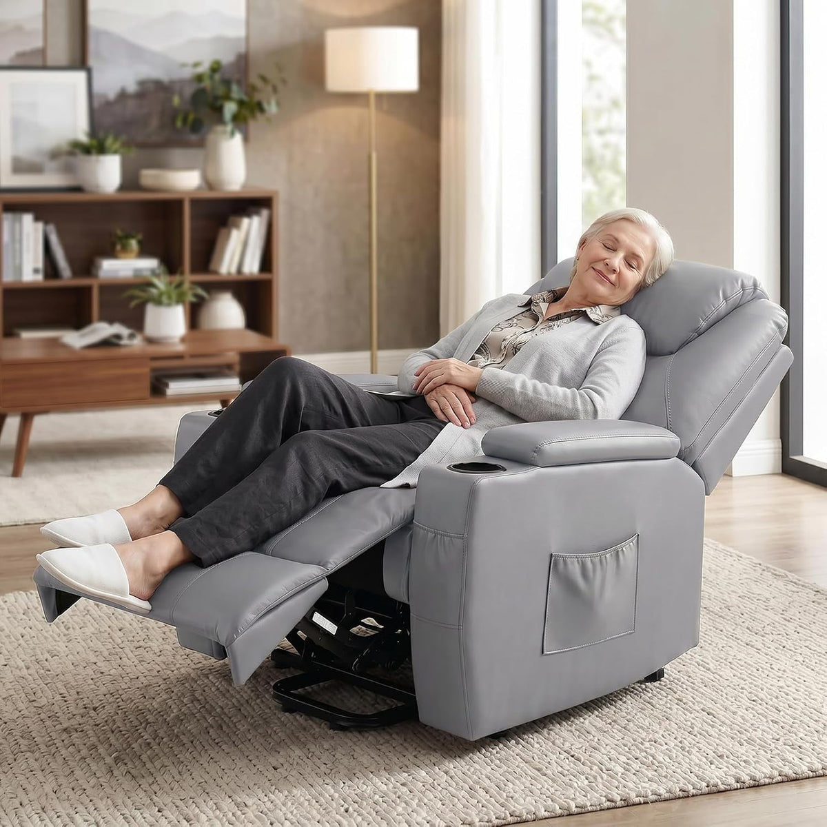 Grey recliner in reclined position with a person napping to show the 140° recline and extended footrest