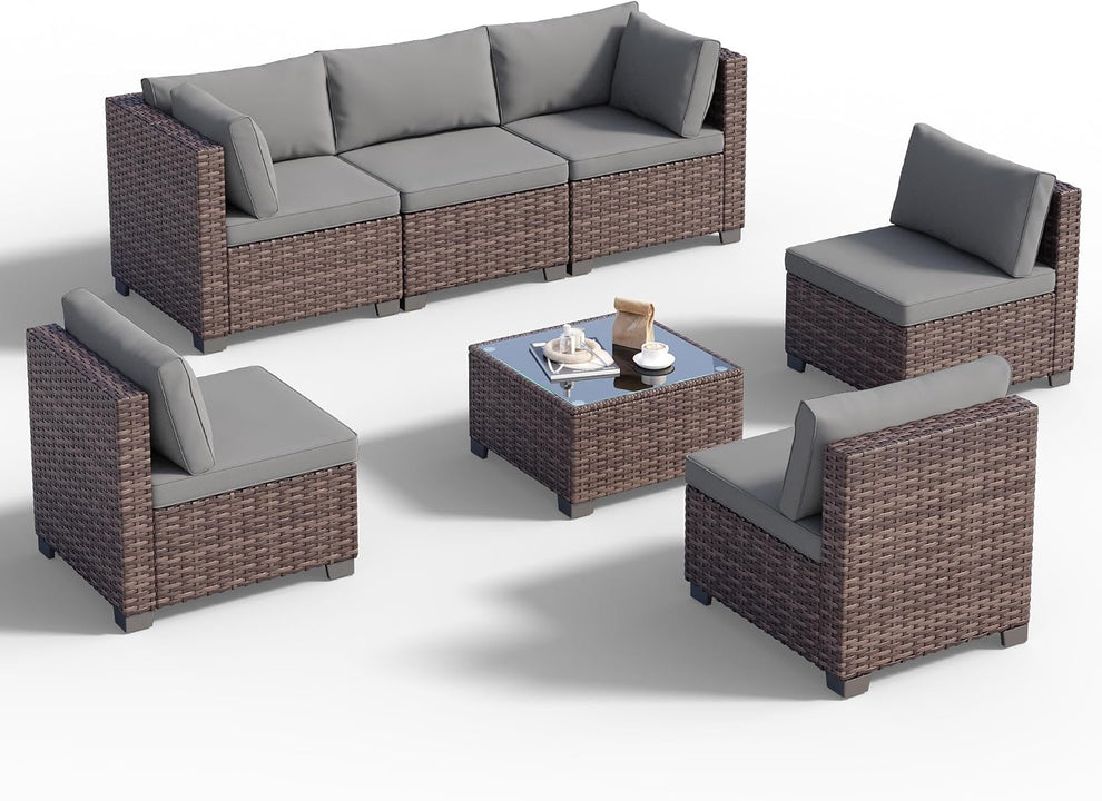 Seven-piece rattan sectional and glass-top coffee table arranged on a white background.