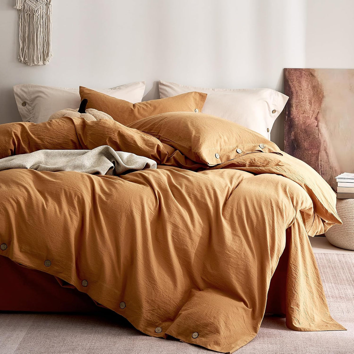 Warm golden-brown duvet set on a bed with pale shams and visible round wooden buttons.