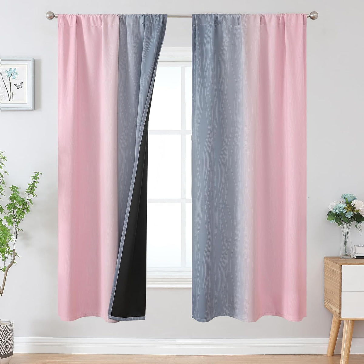 Window with pink-to-grey ombre curtain panels, one panel slightly opened revealing black inner lining.