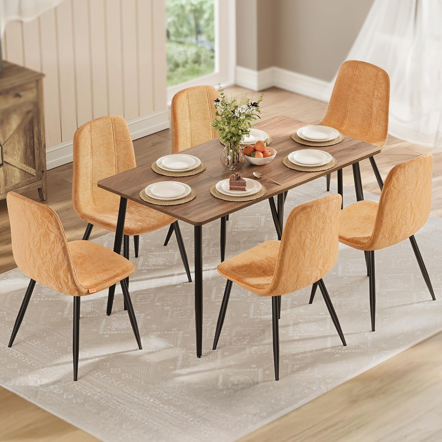 Top-down view of six camel-tan chairs set around a rectangular wood table with place settings