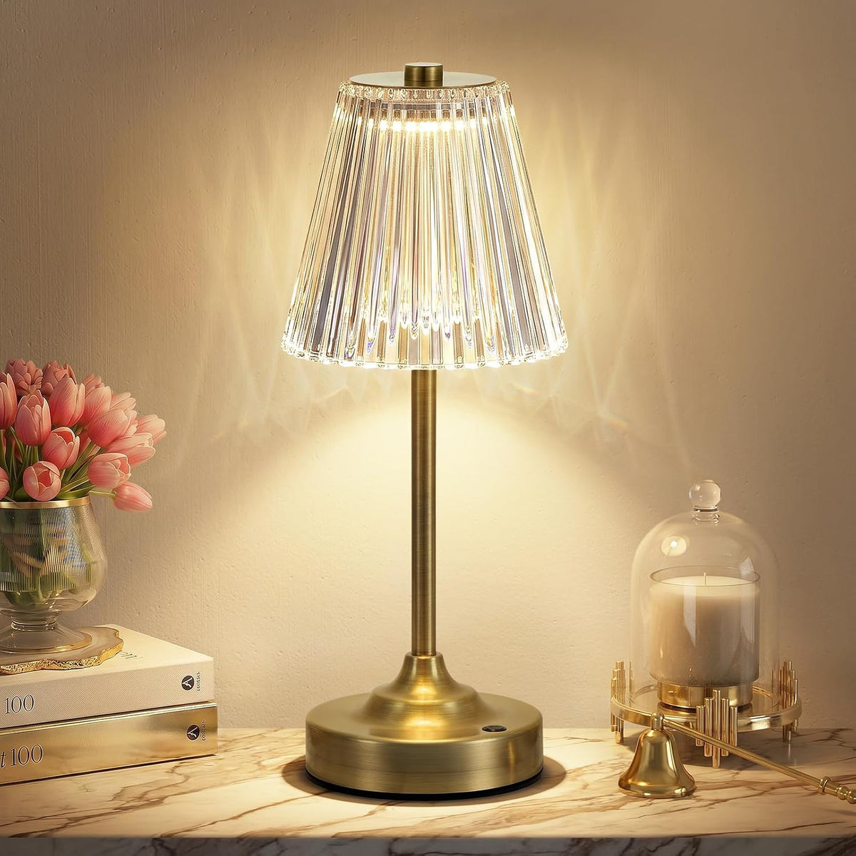 Centered view of the lamp's slender gold stem and round brushed-gold base with a small touch button