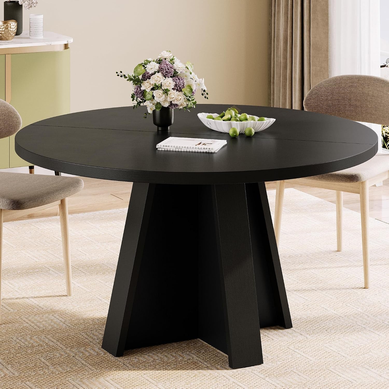 Close side view of the black round table showing panelled pedestal base and seating around it.