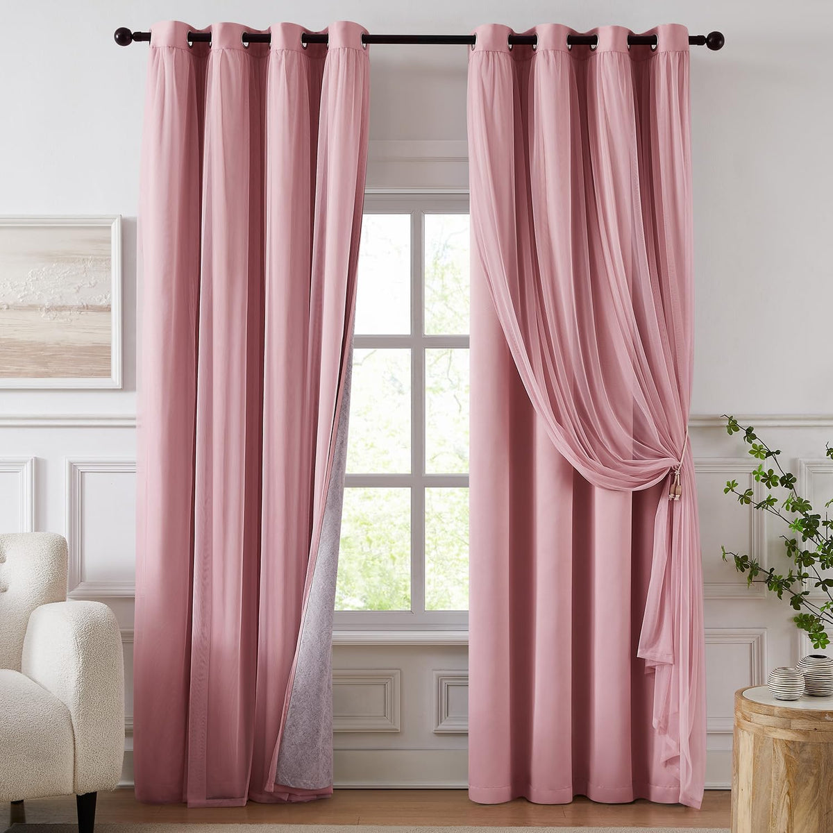 Front view of pink grommet-top curtains with sheer overlay draped and a window visible behind the panels.