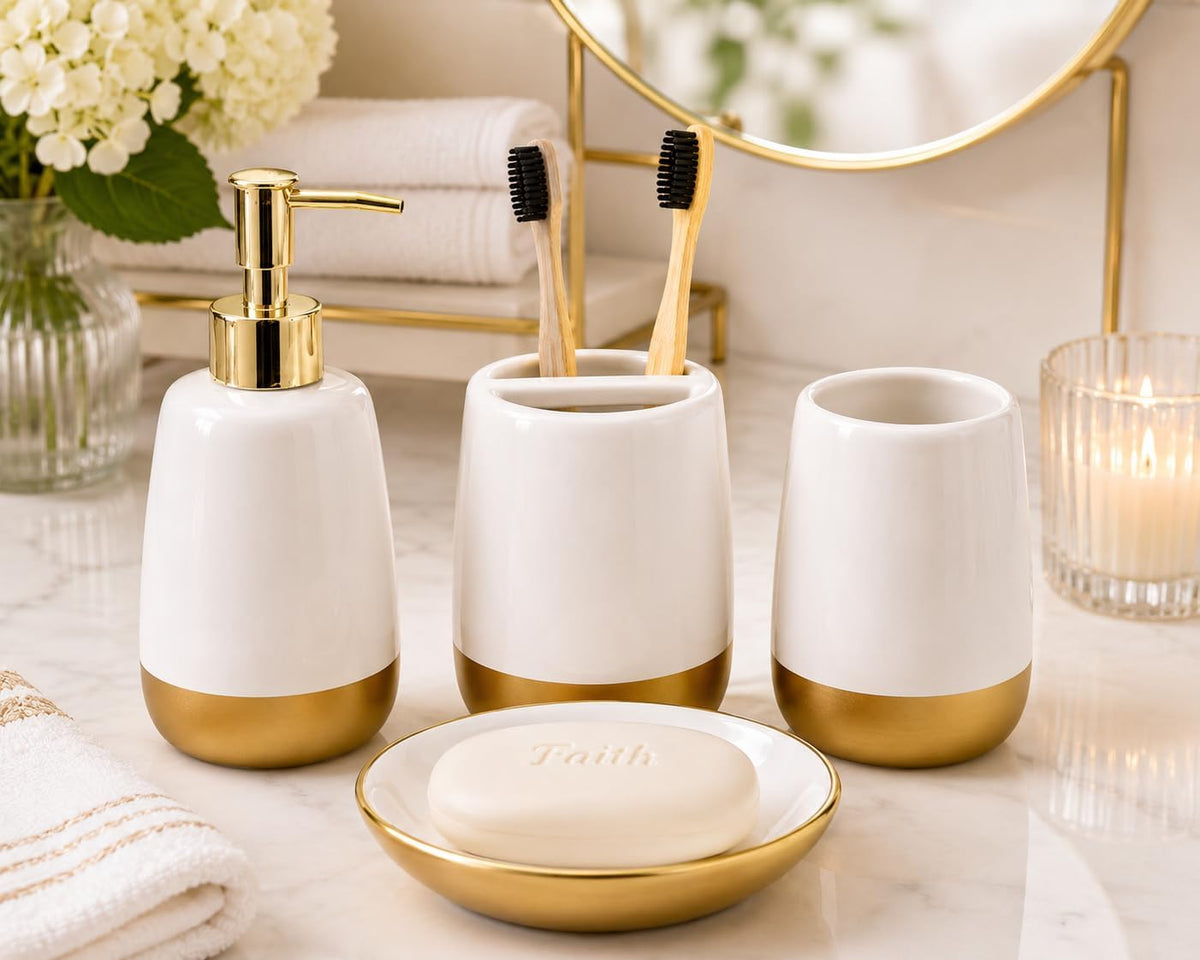White ceramic set with gold accents on a marble countertop, front view with bamboo toothbrushes and a round mirror behind