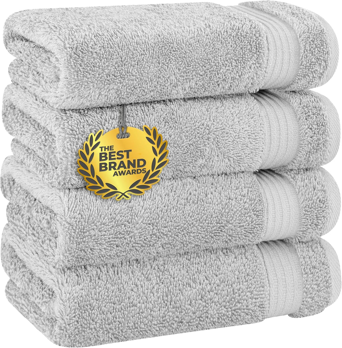 Front view of four neatly stacked white bath towels with a gold award medallion hanging on the front