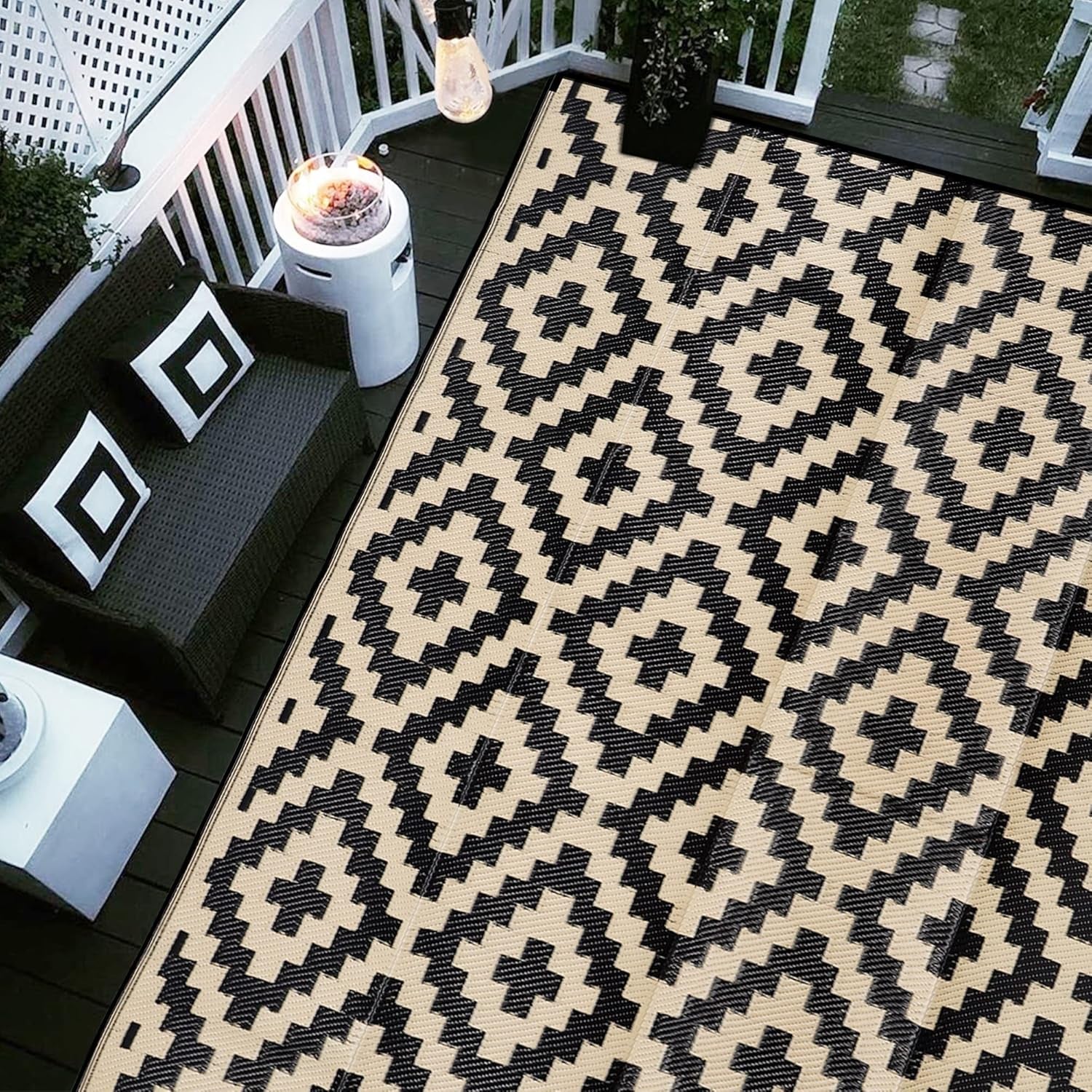 Top-down view of beige rug with black geometric diamond pattern on deck