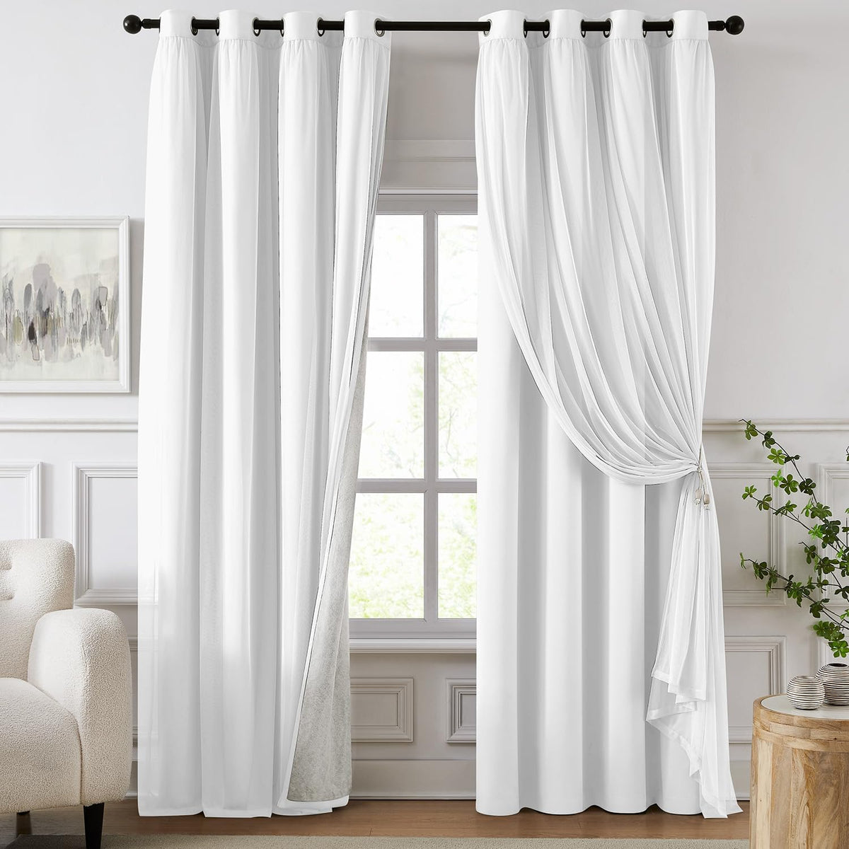 Tall window dressed with double-layer white curtains: opaque panels and a sheer overlay tied back on the right, rod and room