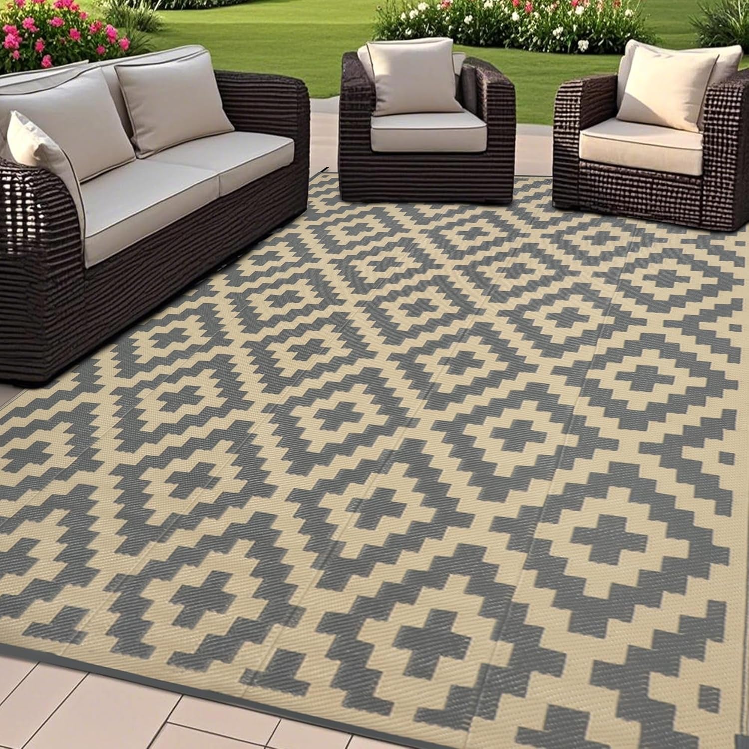 Outdoor patio scene with woven sofa set on a beige-and-gray geometric outdoor rug.