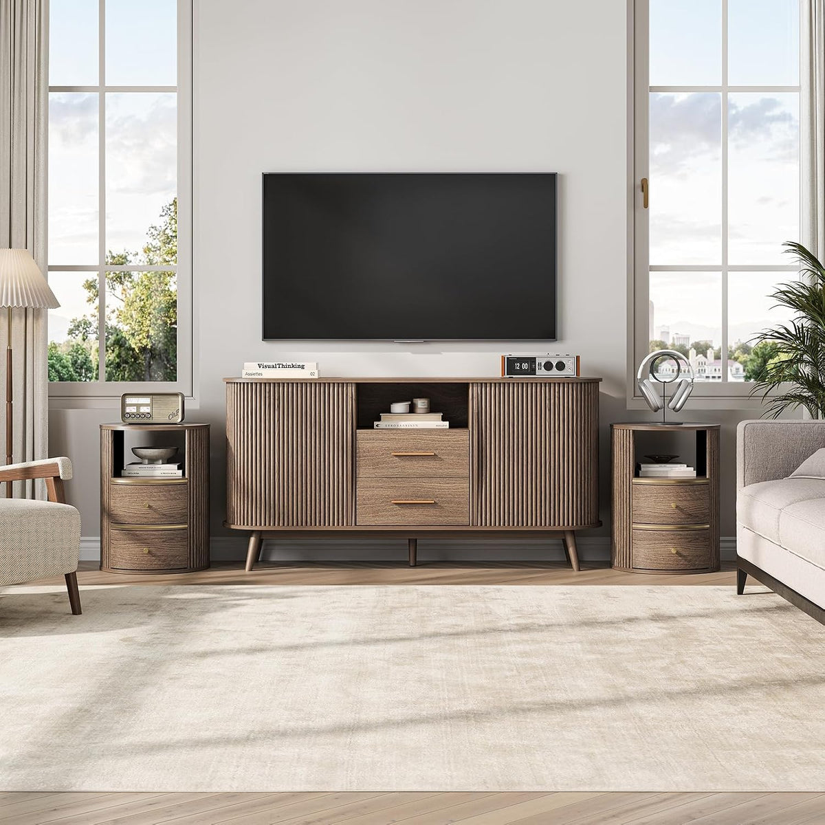 Media console flanked by two matching round fluted nightstands used as end tables under large windows