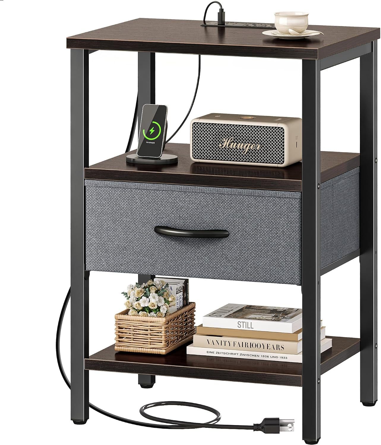 Three-tier nightstand with dark wood shelves, black frame and gray fabric drawer, shown with accessories