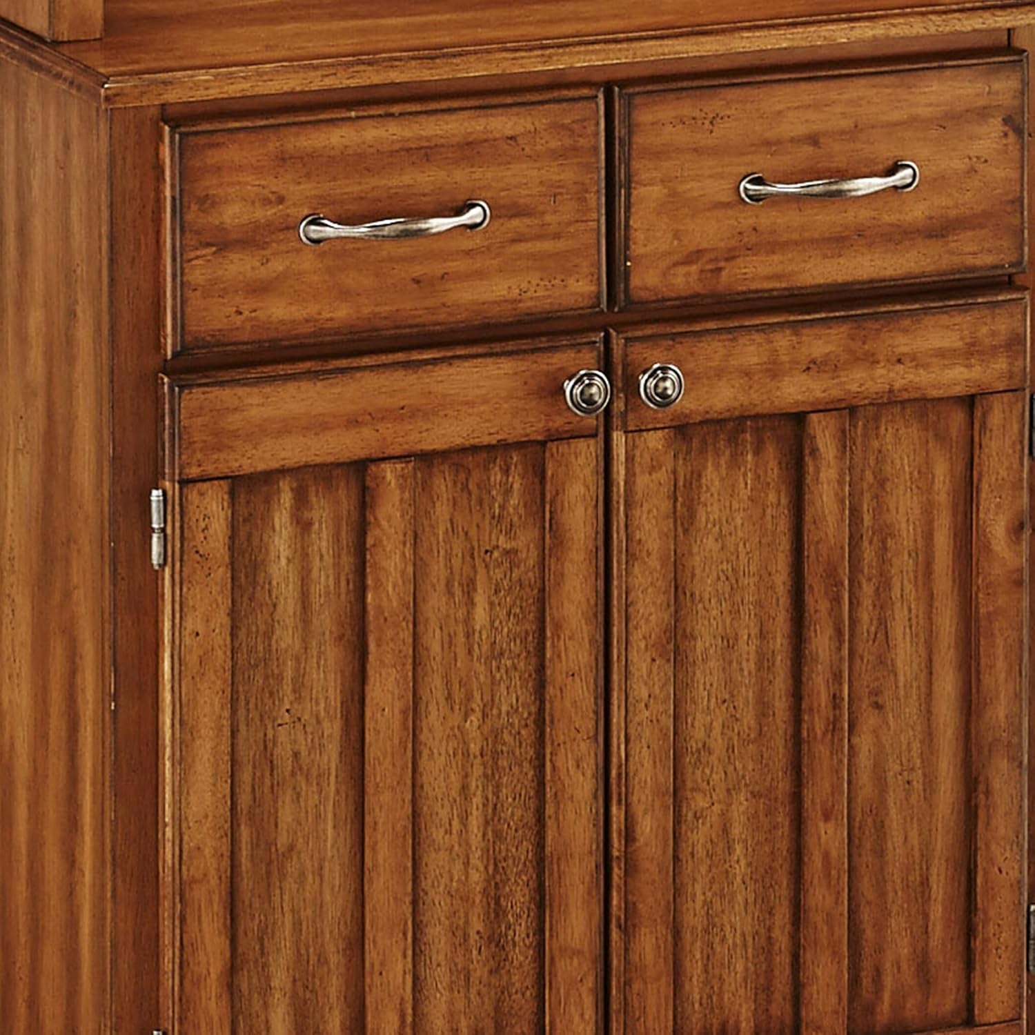 Close-up of top drawers and paneled doors with metal drawer pulls and round knobs