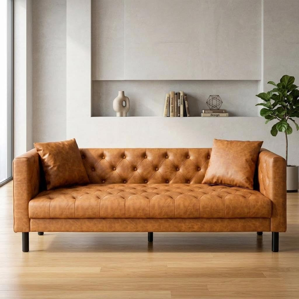 straight-on front view of tufted PU leather three-seat sofa against a minimal wall with plant
