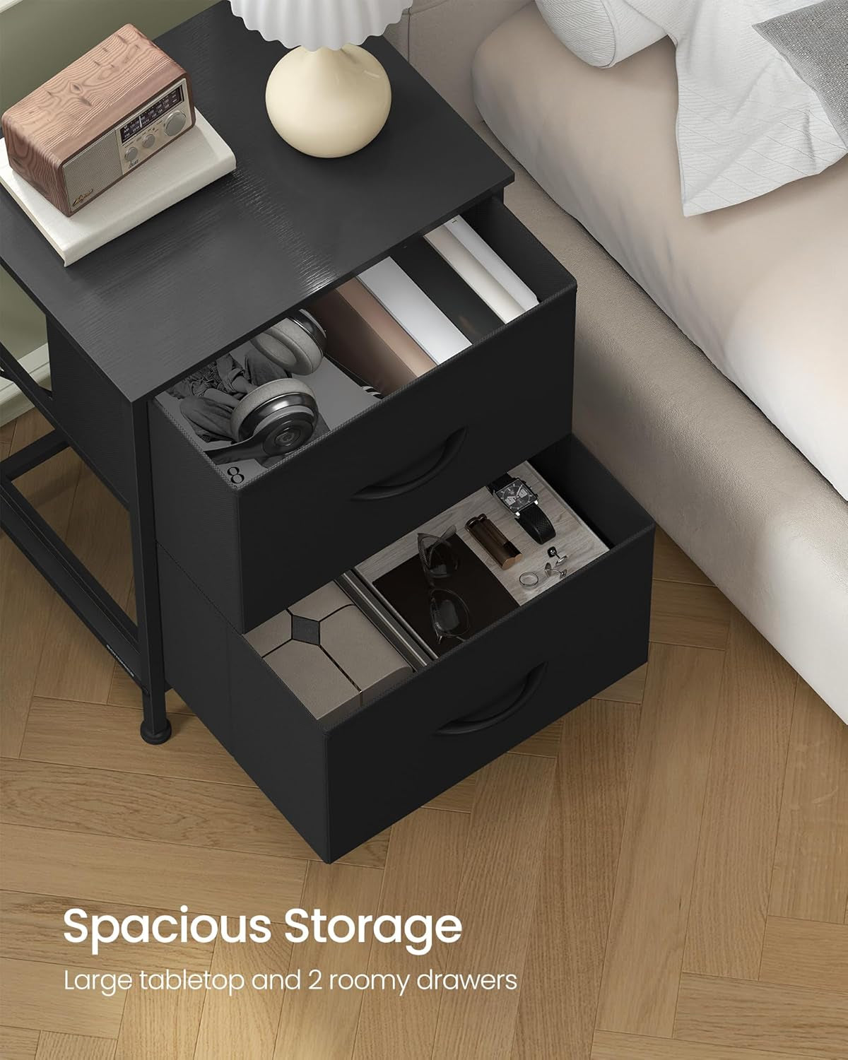 Top-down crop of the bedside chest with open drawers holding accessories