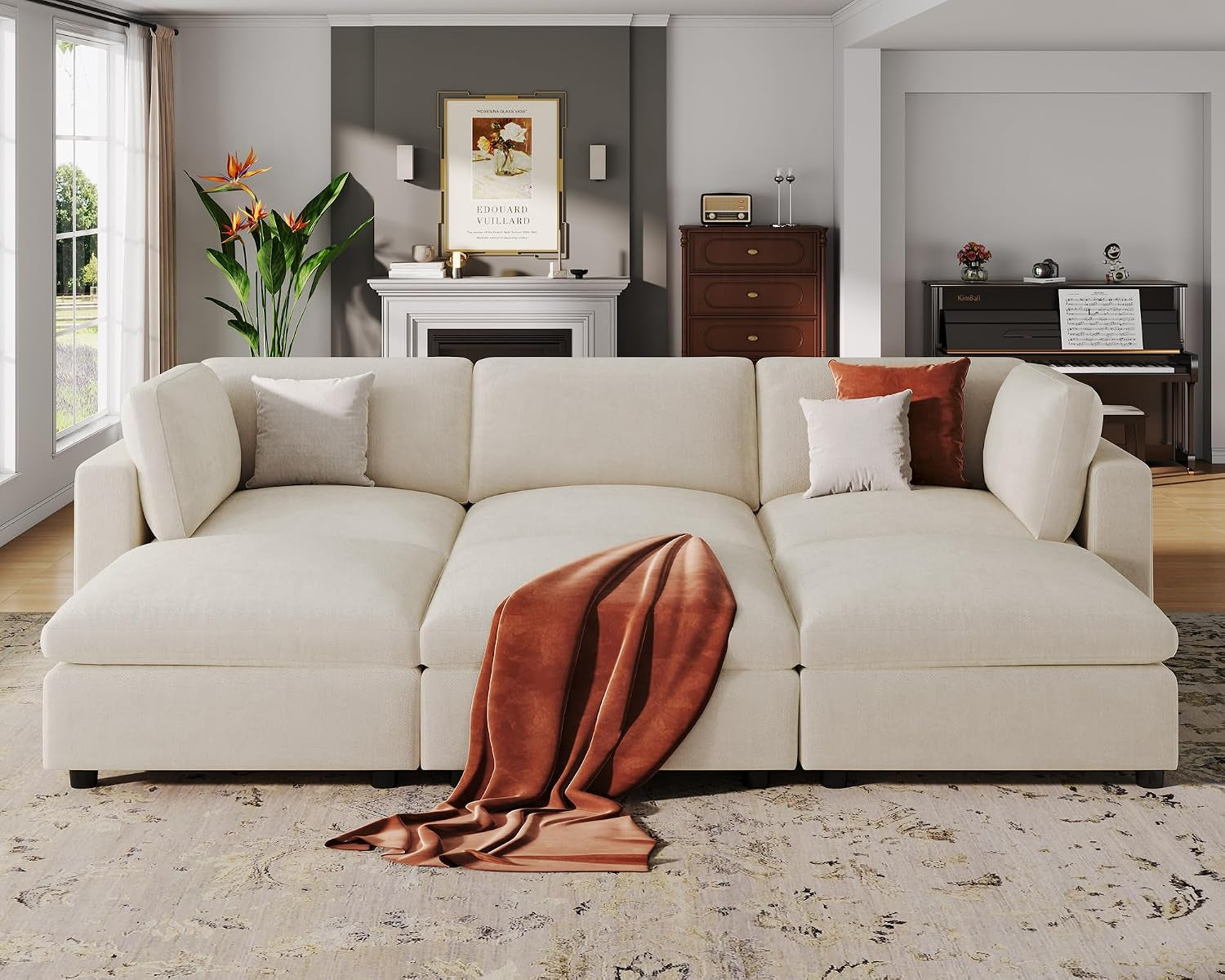 Cream modular corner sectional arranged low with three wide seat cushions and a rust throw draped front.
