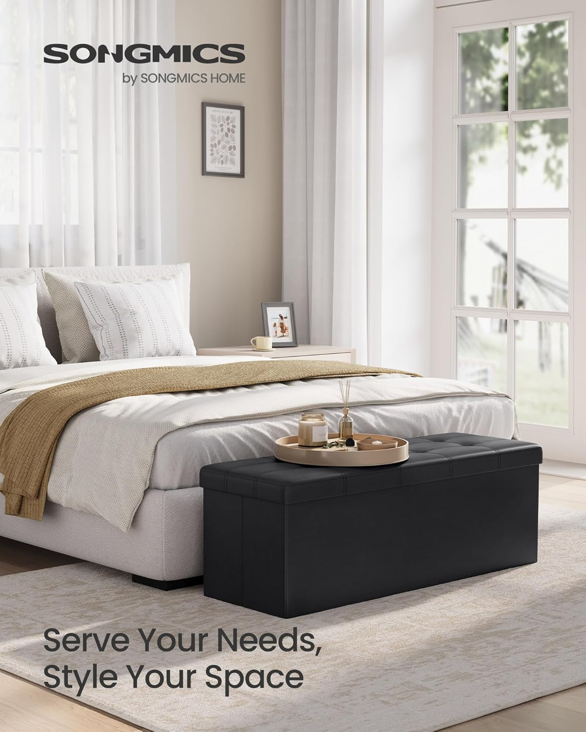 Black storage ottoman placed at the foot of a bed in a styled bedroom scene