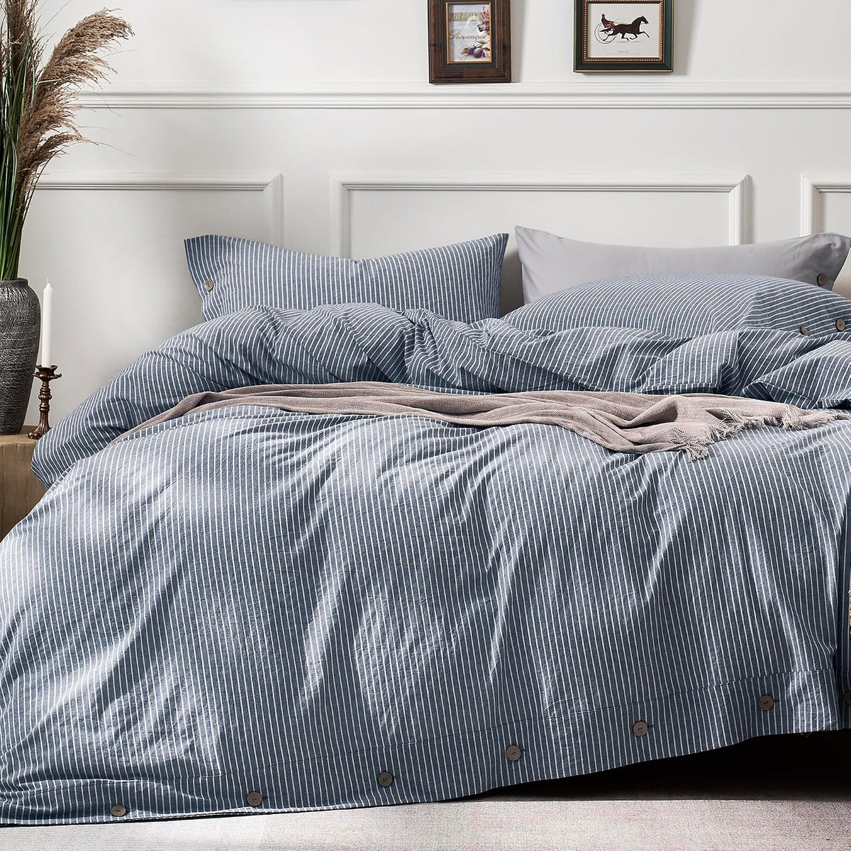 Close-up of a bed dressed in blue-and-white pinstripe duvet and pillows with wooden buttons.