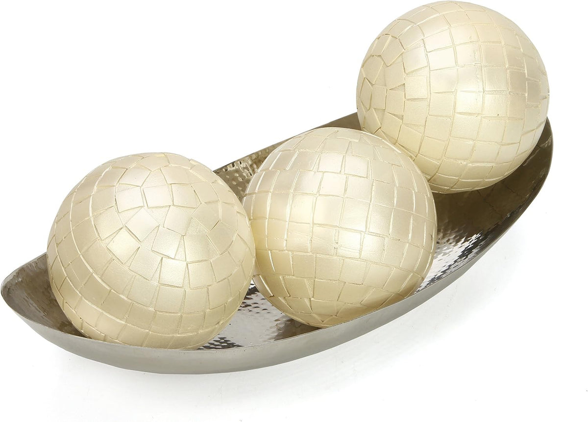 Angled view of the bowl holding three large cream mosaic-pattern decorative spheres