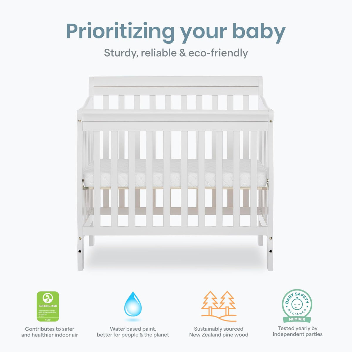 Front-facing white mini crib centered on a light background with small icons along the bottom.