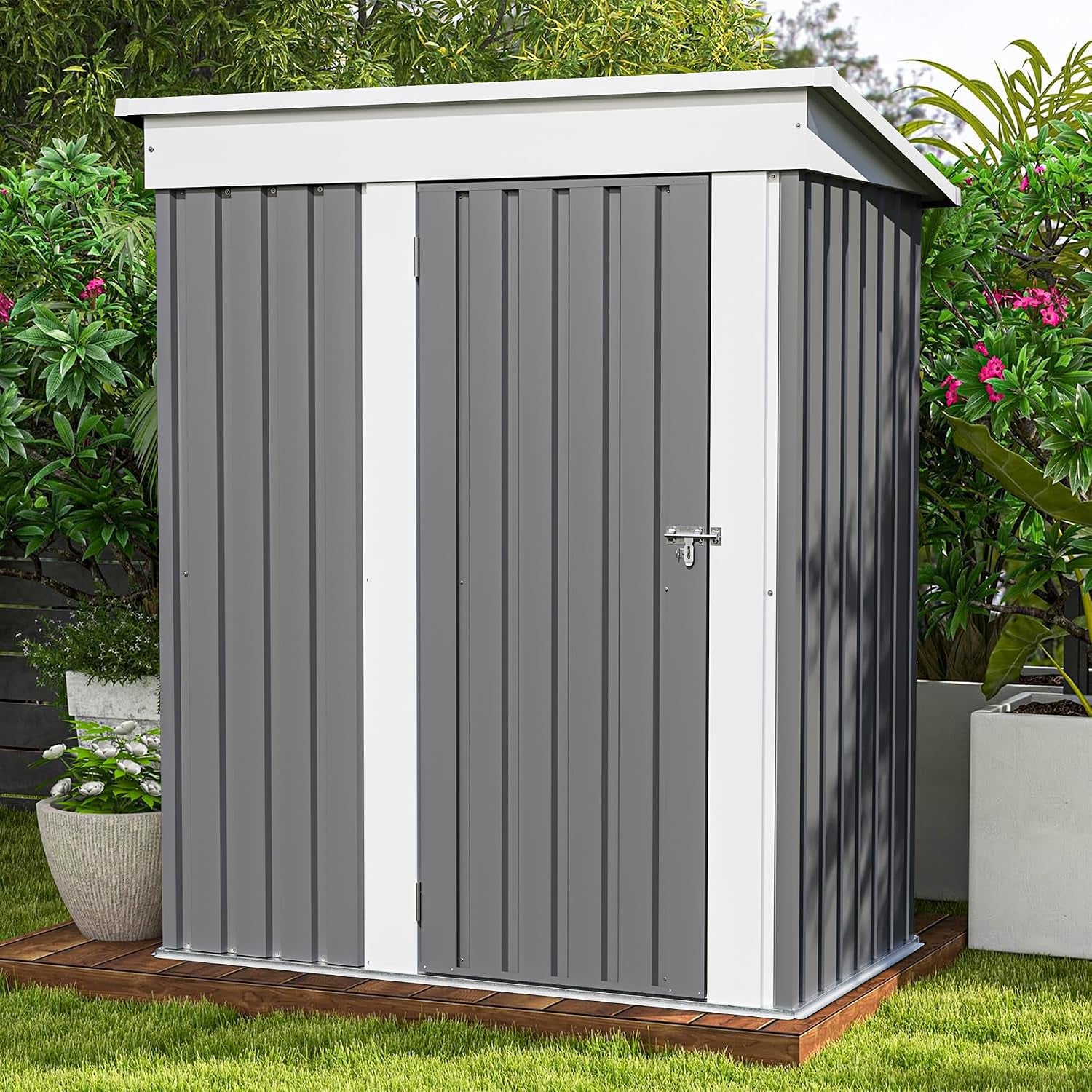 Small gray metal storage shed with white trim and a padlock has a sloping roof, shown on a wooden base.