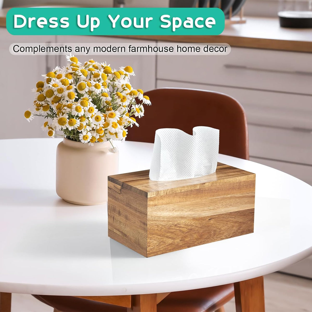 Front view of acacia wood tissue box cover on a round white table next to a vase of flowers with a tissue visible