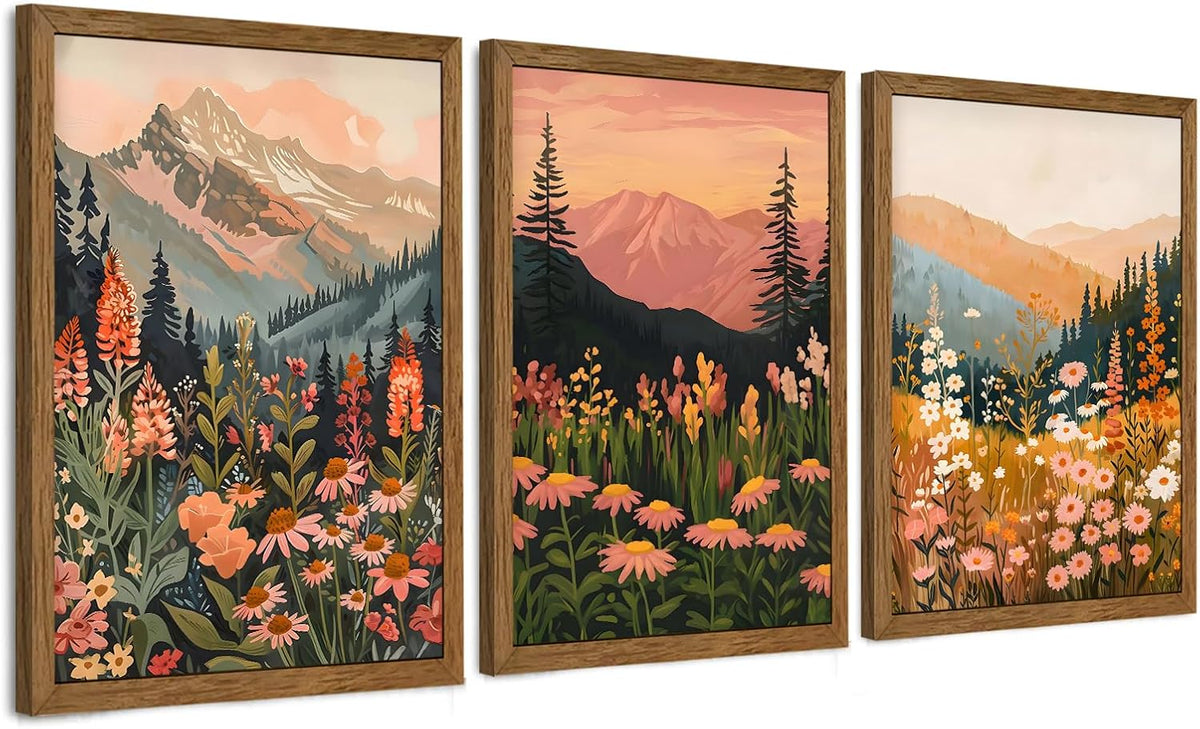 Three framed floral mountain prints seen at an angle, showing wood frame edges and reflective floor shadow.