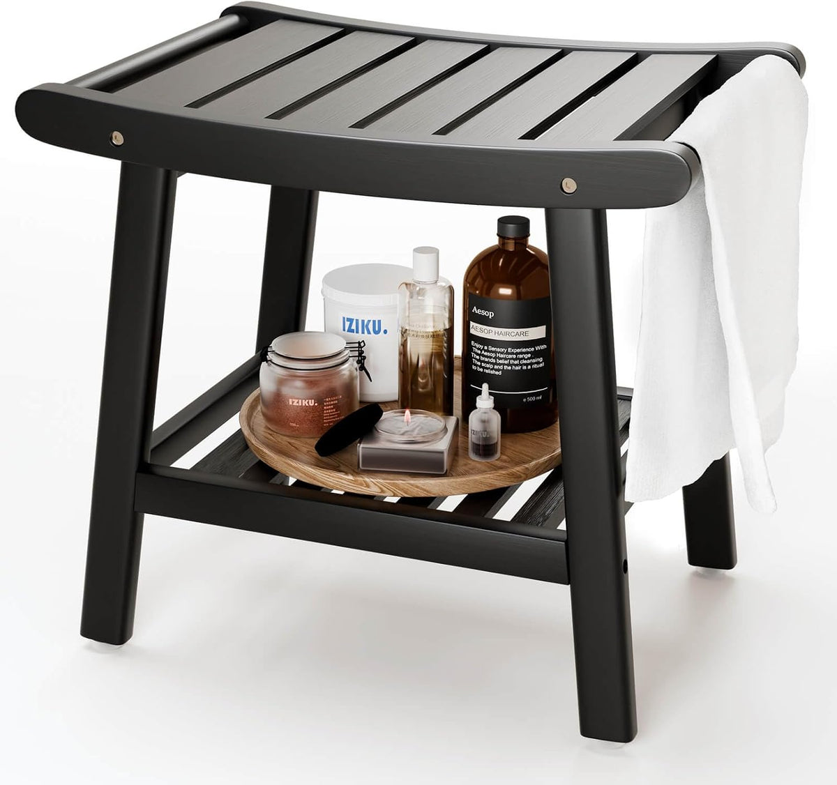 Close-up of a black wooden shower stool showing slatted top, lower shelf with bottles and a towel draped over the side.