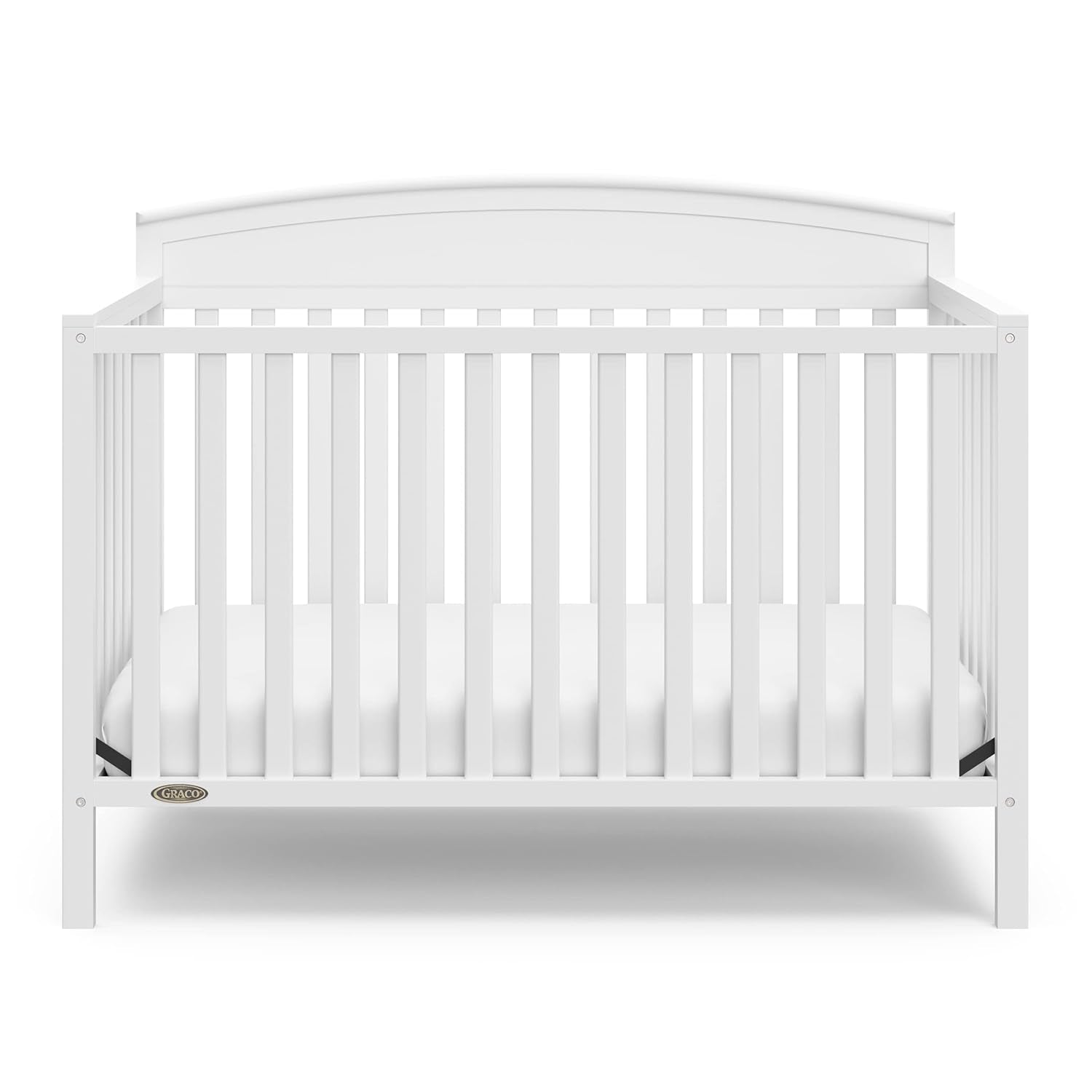 Head-on front view of the white crib showing slatted front and mattress inside.