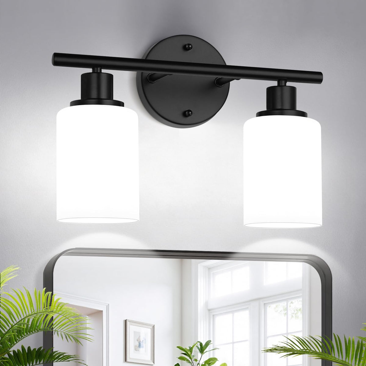 Close view of a two-light black wall sconce with white/bright cylindrical shades above a mirror.