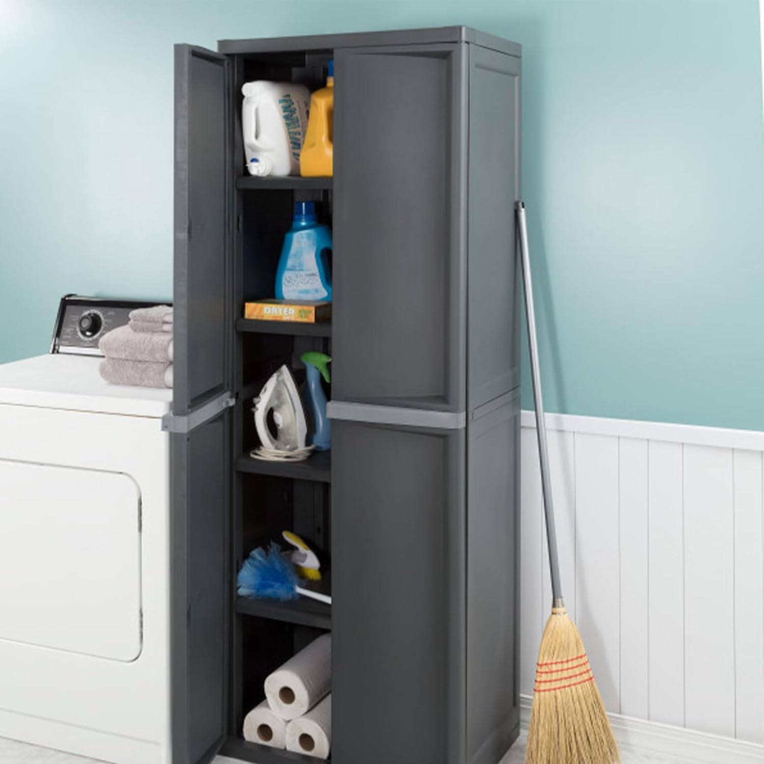 Narrow view of the gray cabinet open beside a washer, showing four interior shelves stocked with supplies.