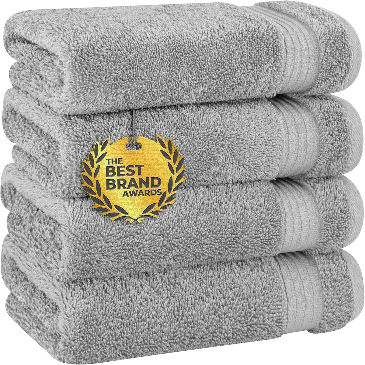 Four light gray towels neatly stacked to show plush pile and ribbed band on the edge.