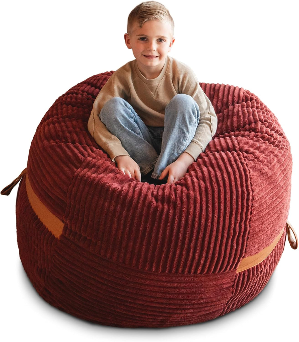 Child perched in the center of a rust-red corded lounger with a visible tan strap on the side