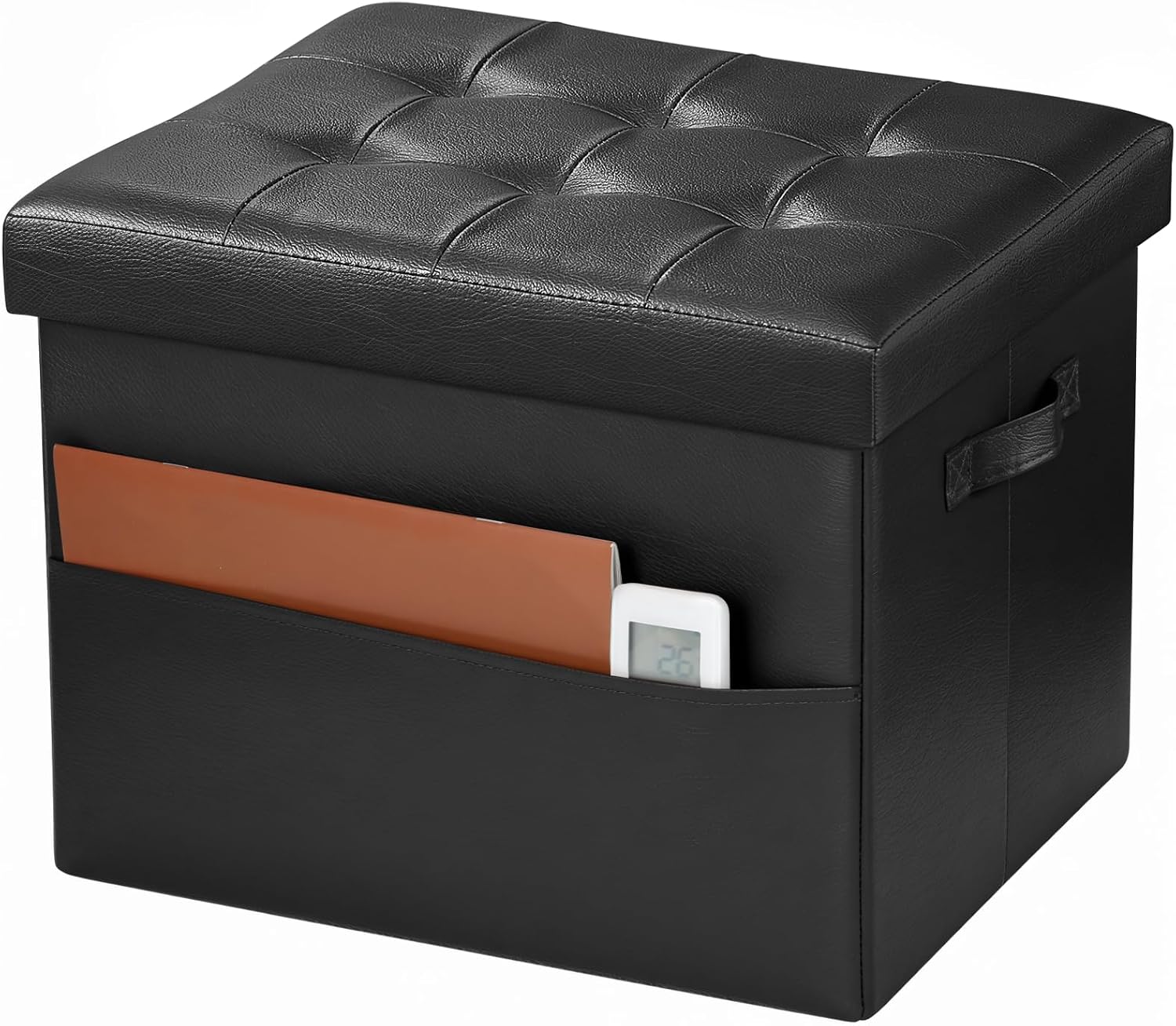 Black faux-leather ottoman with tufted lid, side handle and a slim pocket holding a tablet and small device.
