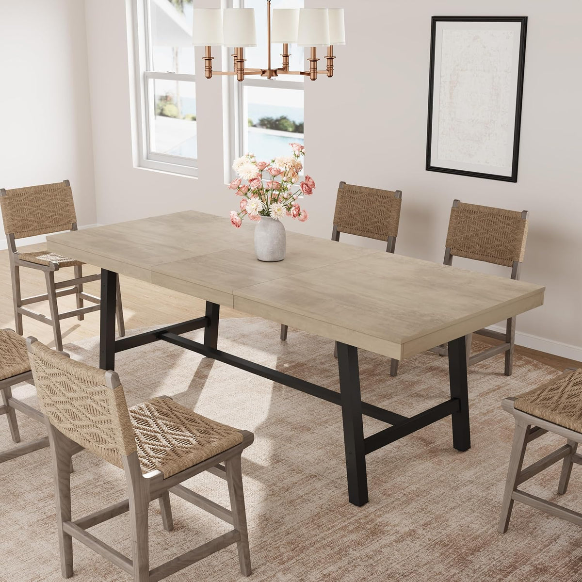 Angled view of extended dining table with light woodgrain top and black metal legs on a hardwood floor