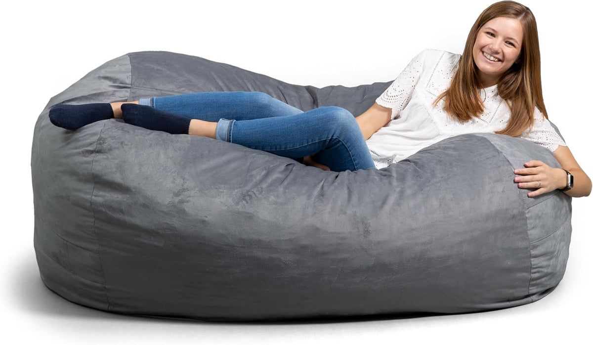 Side view of a gray oversized lounger with a woman reclining along its length.