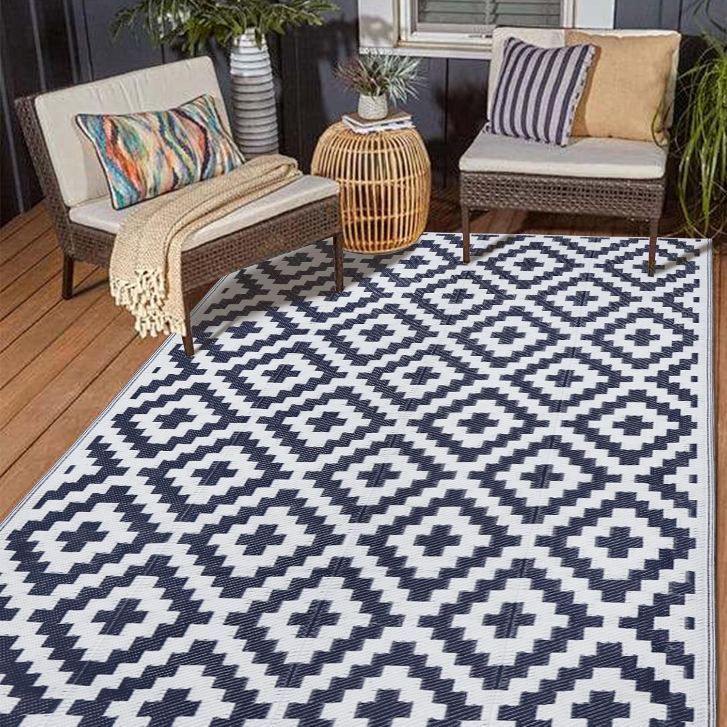 Small deck vignette with a white rug patterned in navy geometric diamonds under two chairs