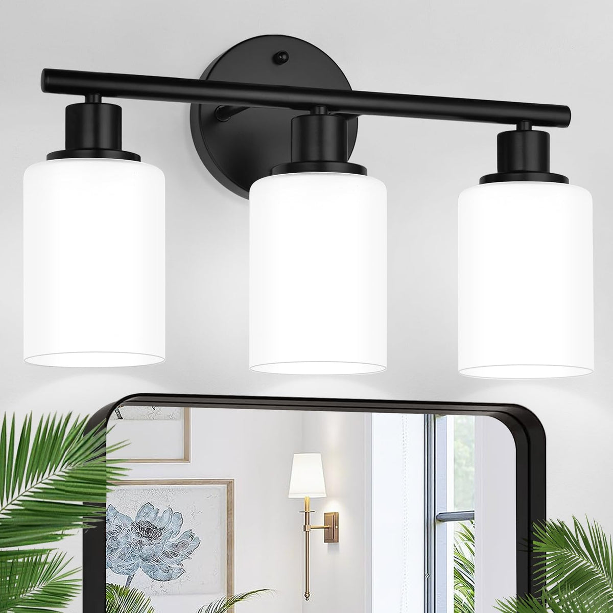 Three-bulb wall fixture with matte black fittings and white frosted shades shown above a mirror