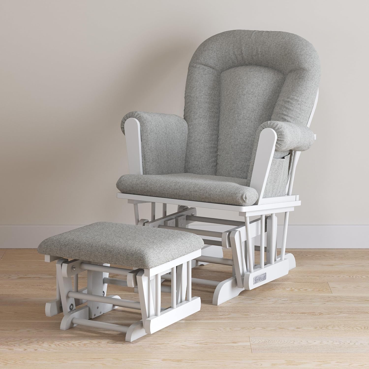 Three-quarter view of white-framed glider rocker and matching ottoman with textured gray cushions.