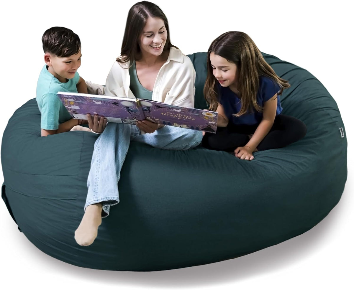 Adult and two children reading together while seated on a deep teal oversized lounger.