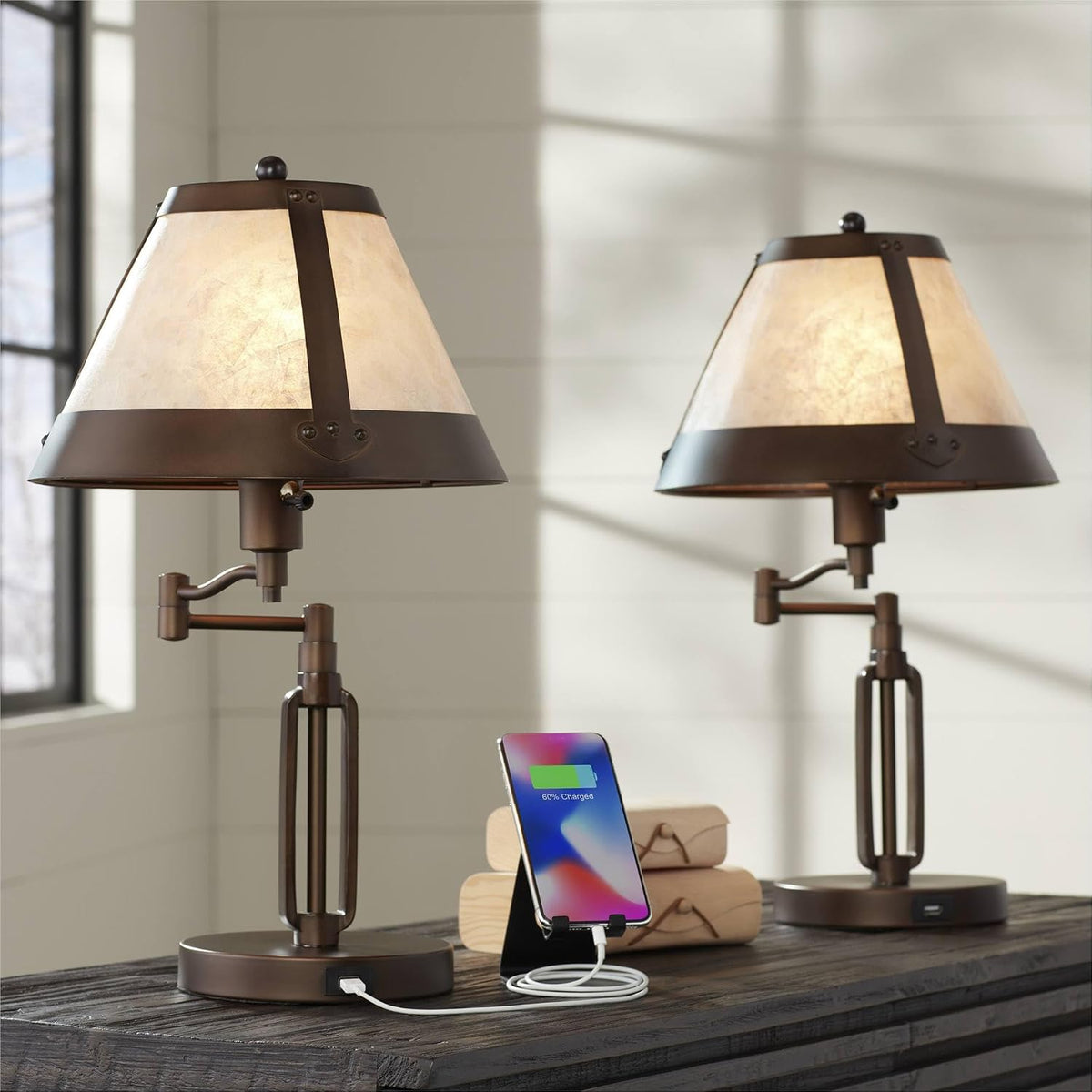 Pair of lamps on a dark wood surface with soft daylight casting window-grid shadows behind them