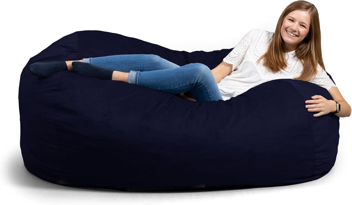 Side view of a long navy lounger with a woman reclining and smiling at the camera.