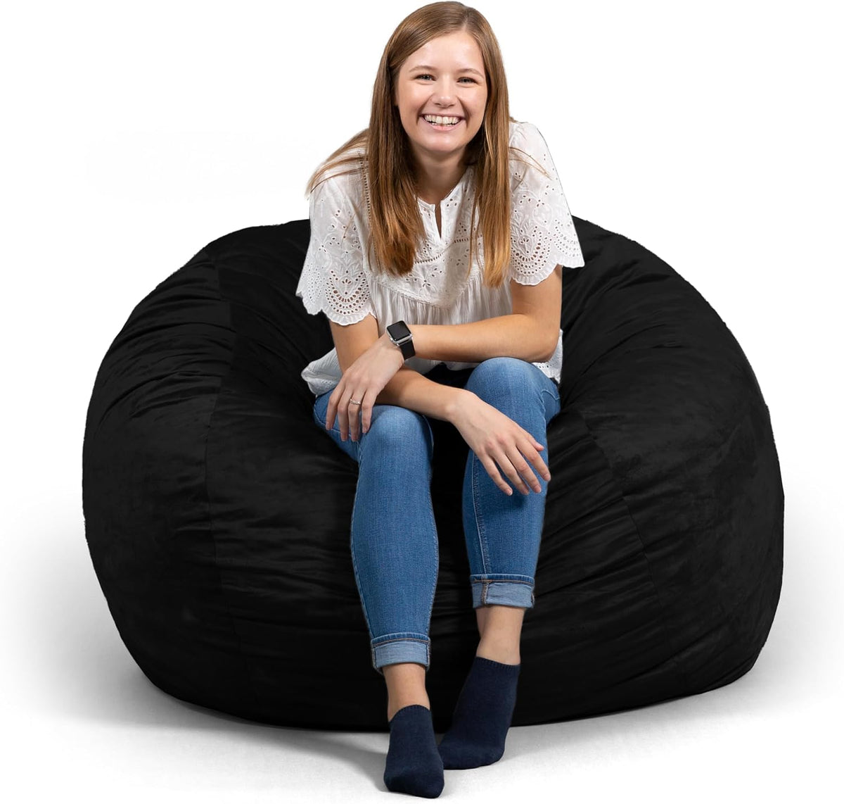 Teen smiling while seated on an oversized black bean bag chair