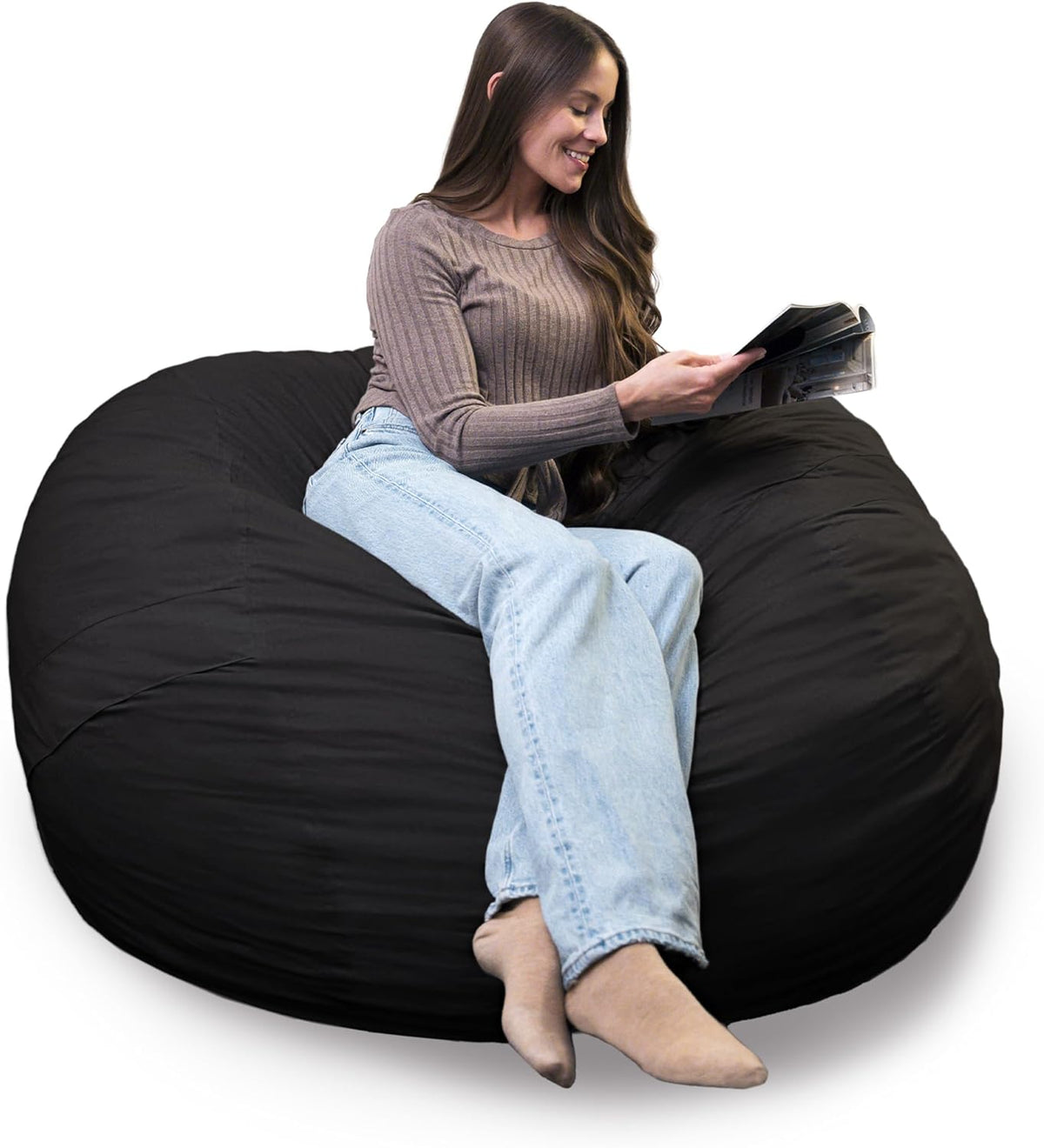 Woman sitting and reading on a large black round bean bag chair