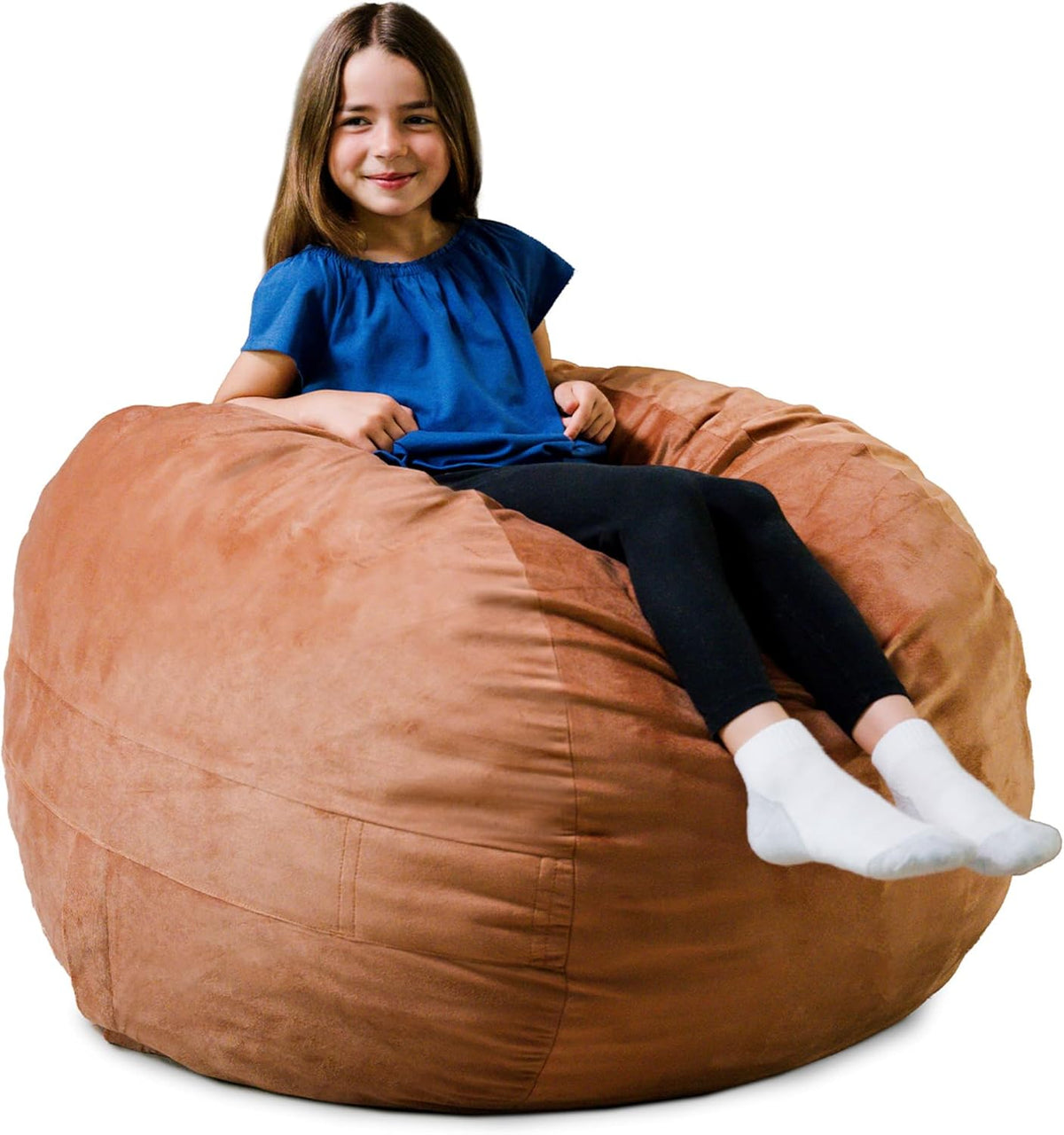 Cropped front shot of a girl sitting on a tan oversized lounger, showing rounded stitched panels and soft texture.